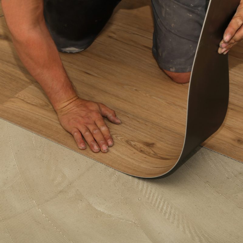 A worker installing new vinyl tile floor